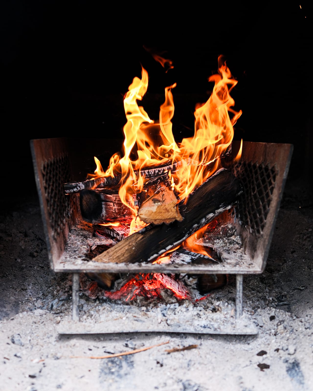 Oak fire burning low in a steel firebox at Apocalypse BBQ in Kendall, Miami